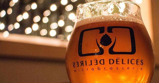 Délires et Délices logo on a beer glass full of beer