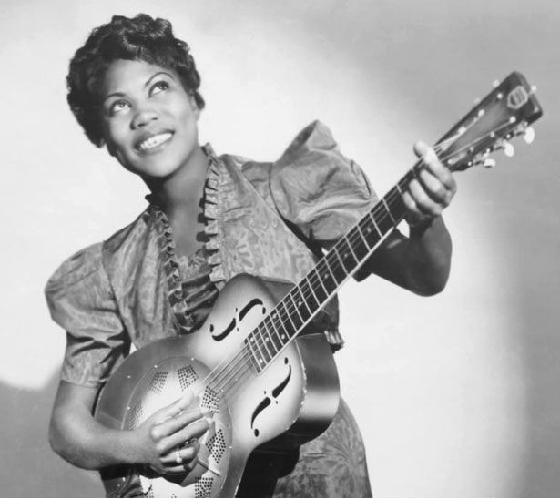 Femme souriante, jouant de la guitare