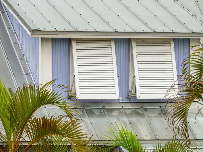 A house with a metal roof and white shutters on the windows.