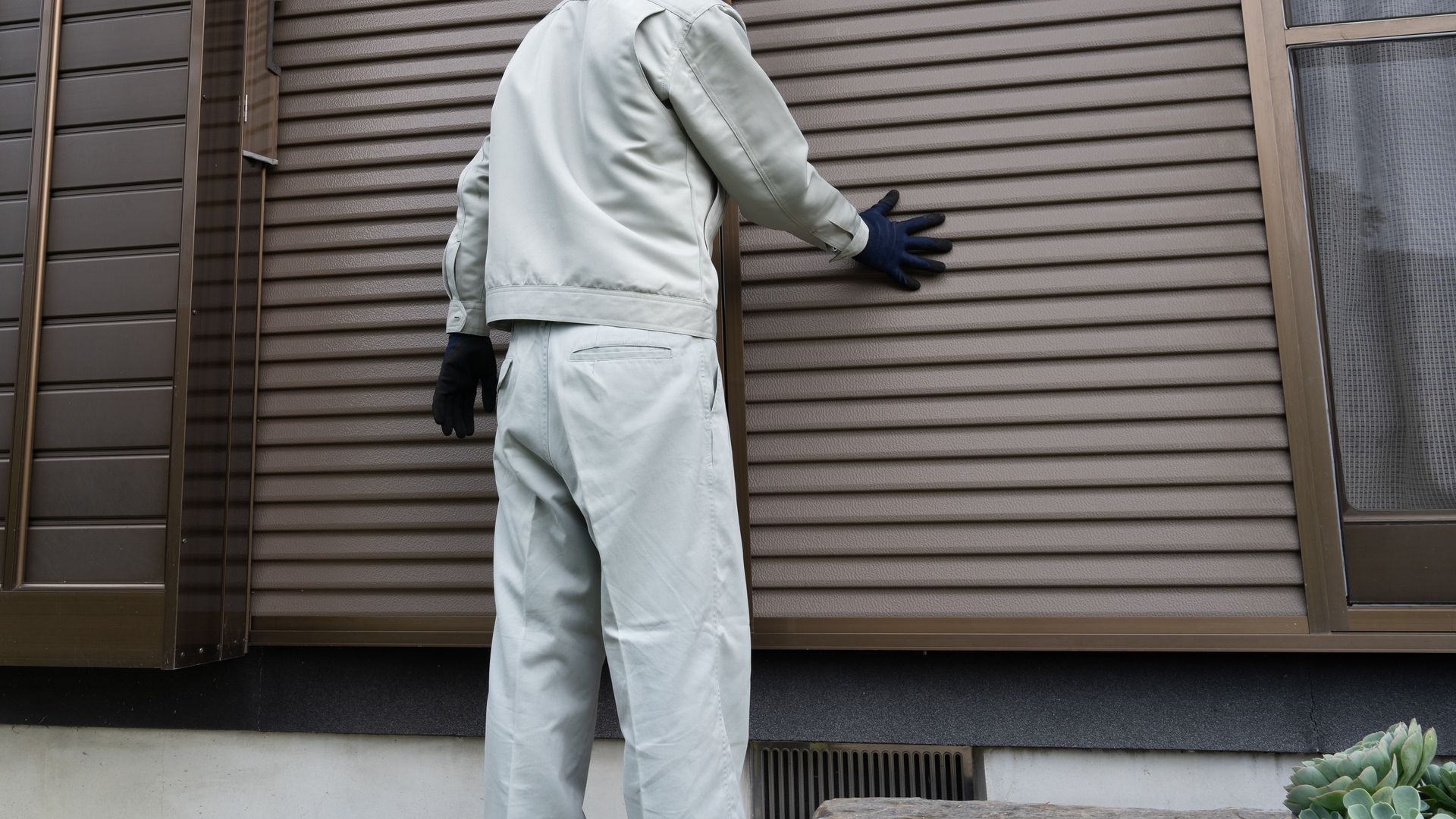 A man checking the newly installed shutter.