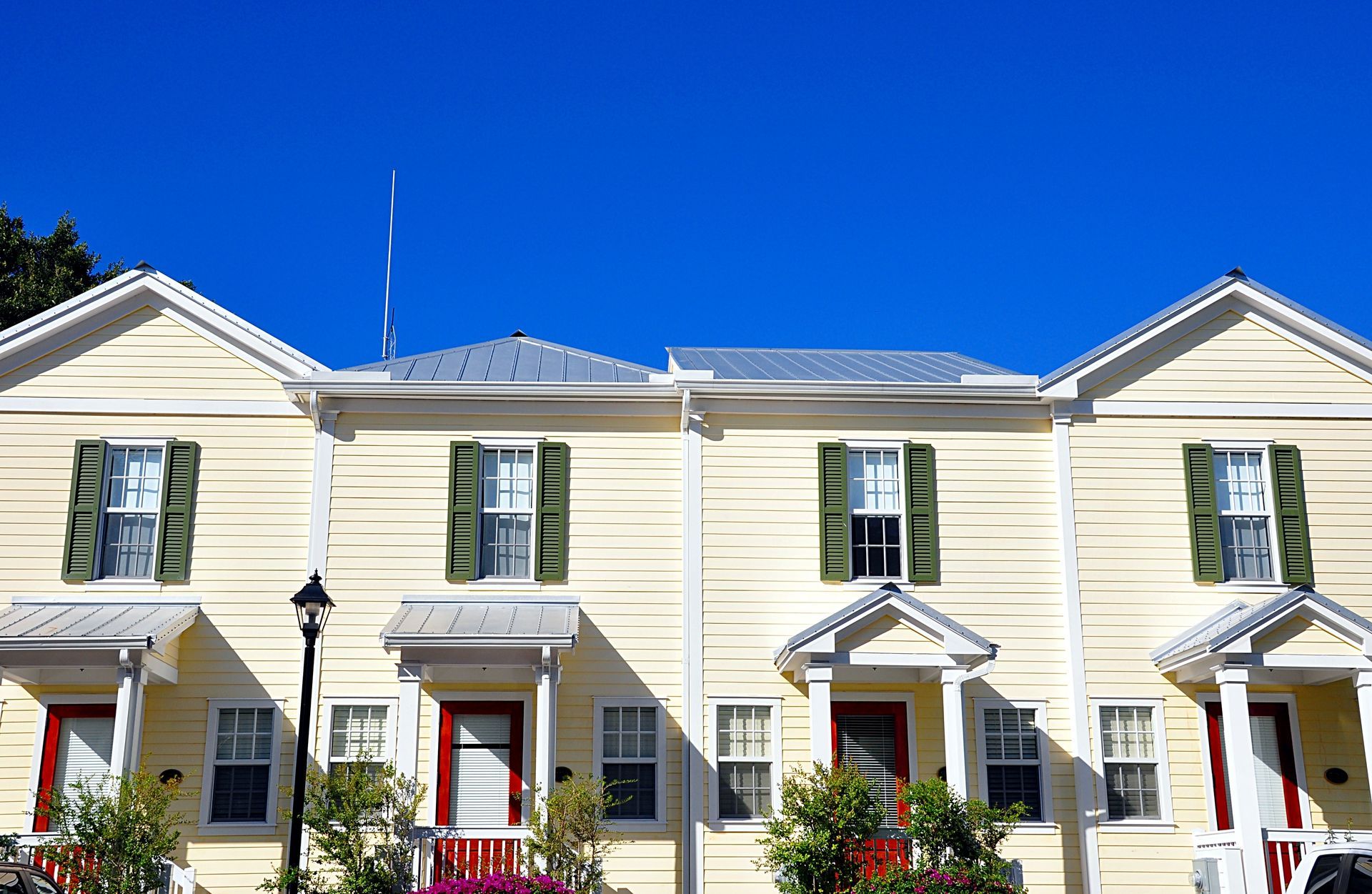 A row of houses with green shutters and red doors
