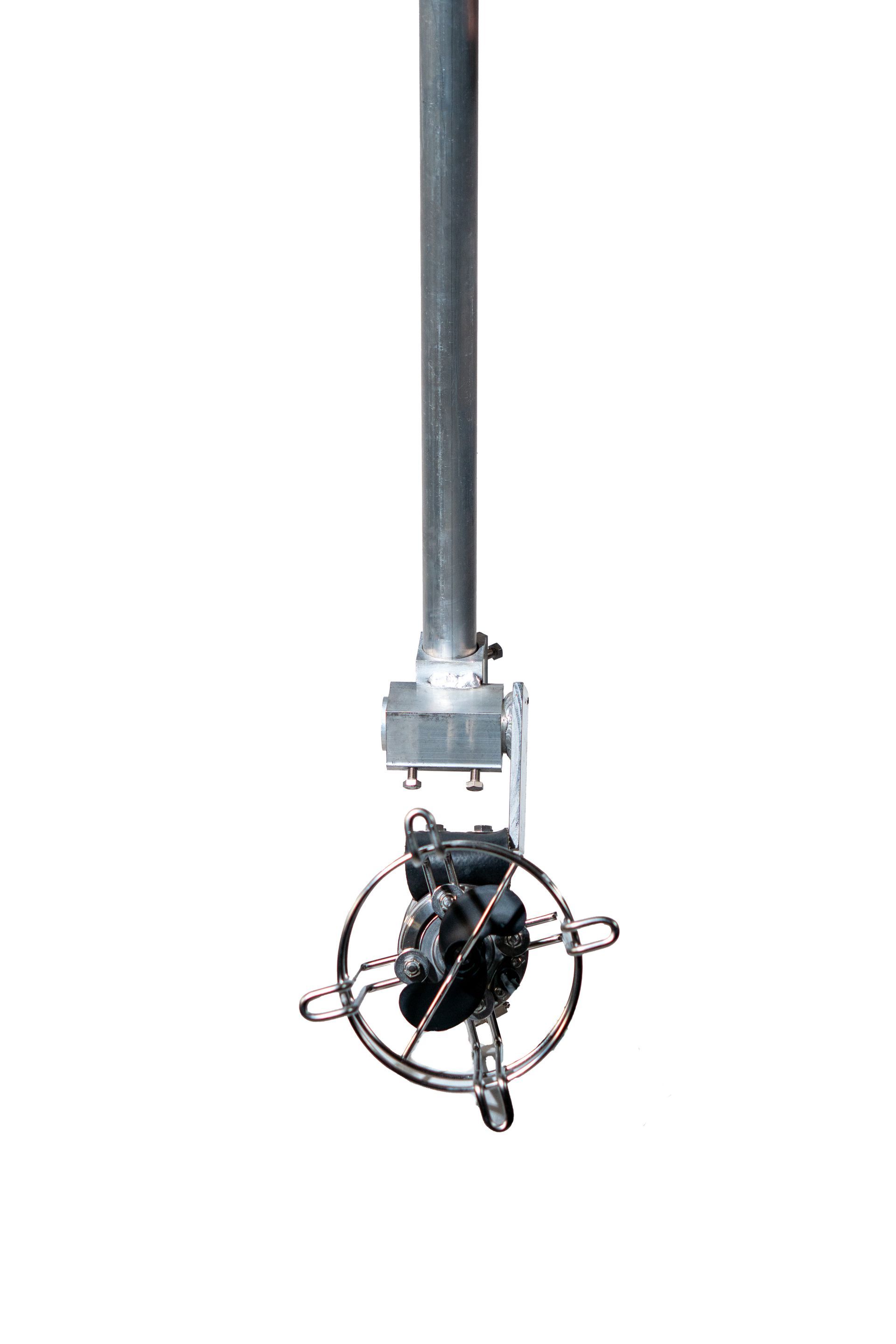 Device hanging from a metal pole, suspended against a white background.