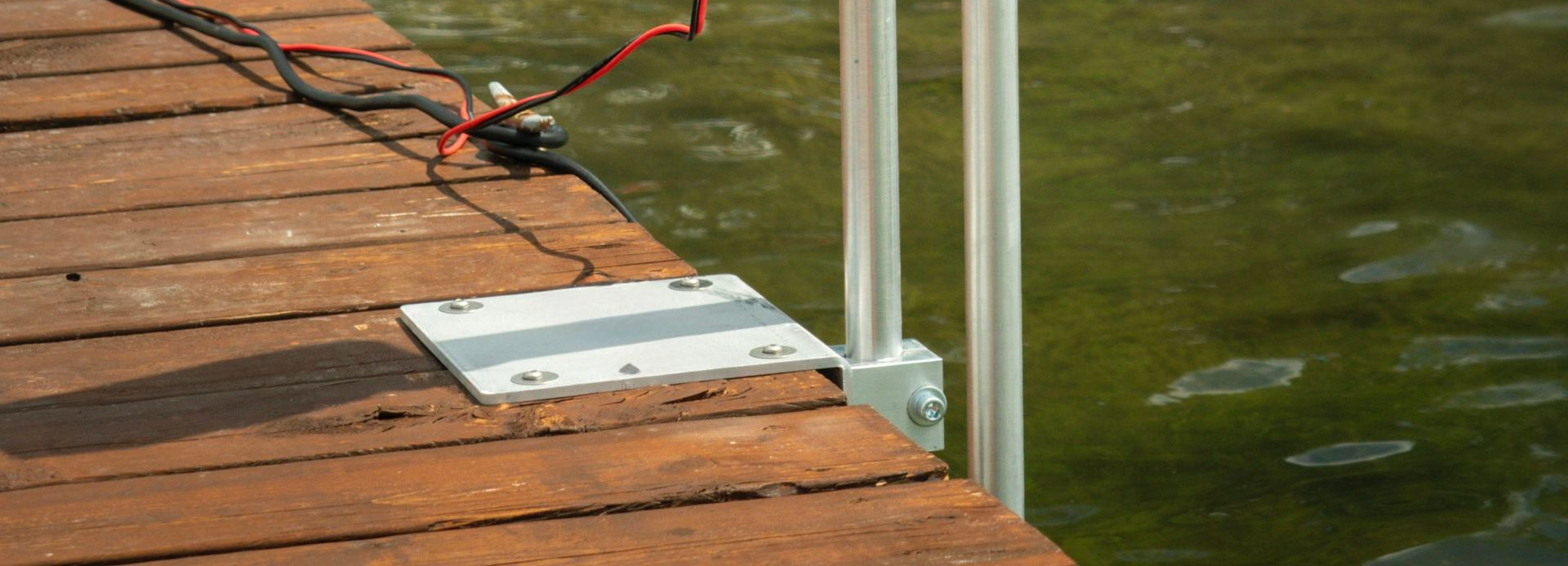 Dock-mounted water circulator support system installed beside a waterfront dock.