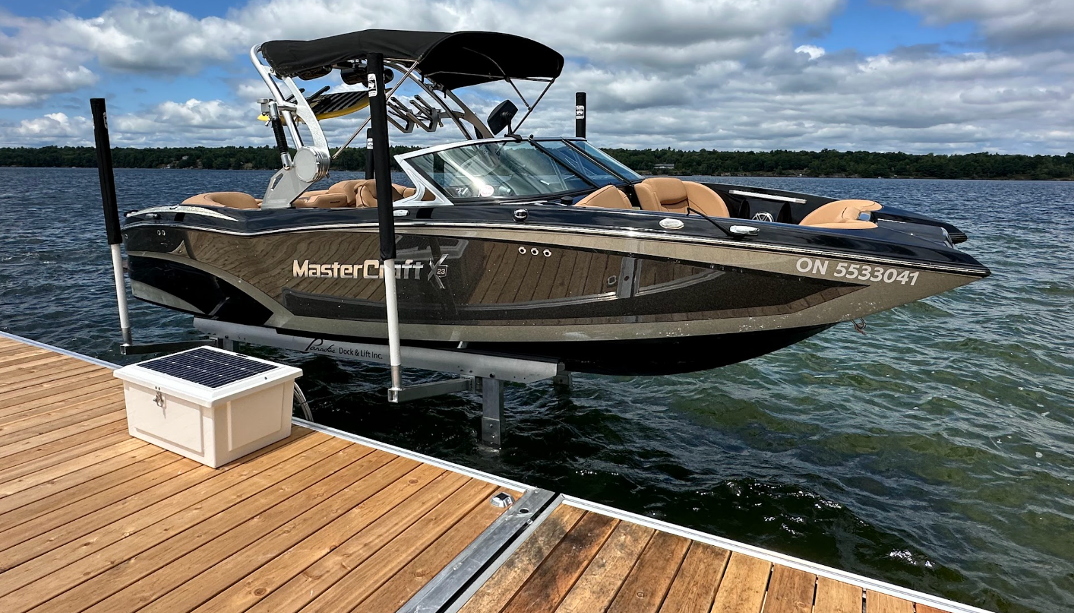 Boat on a lift beside a dock on a Canadian lake.