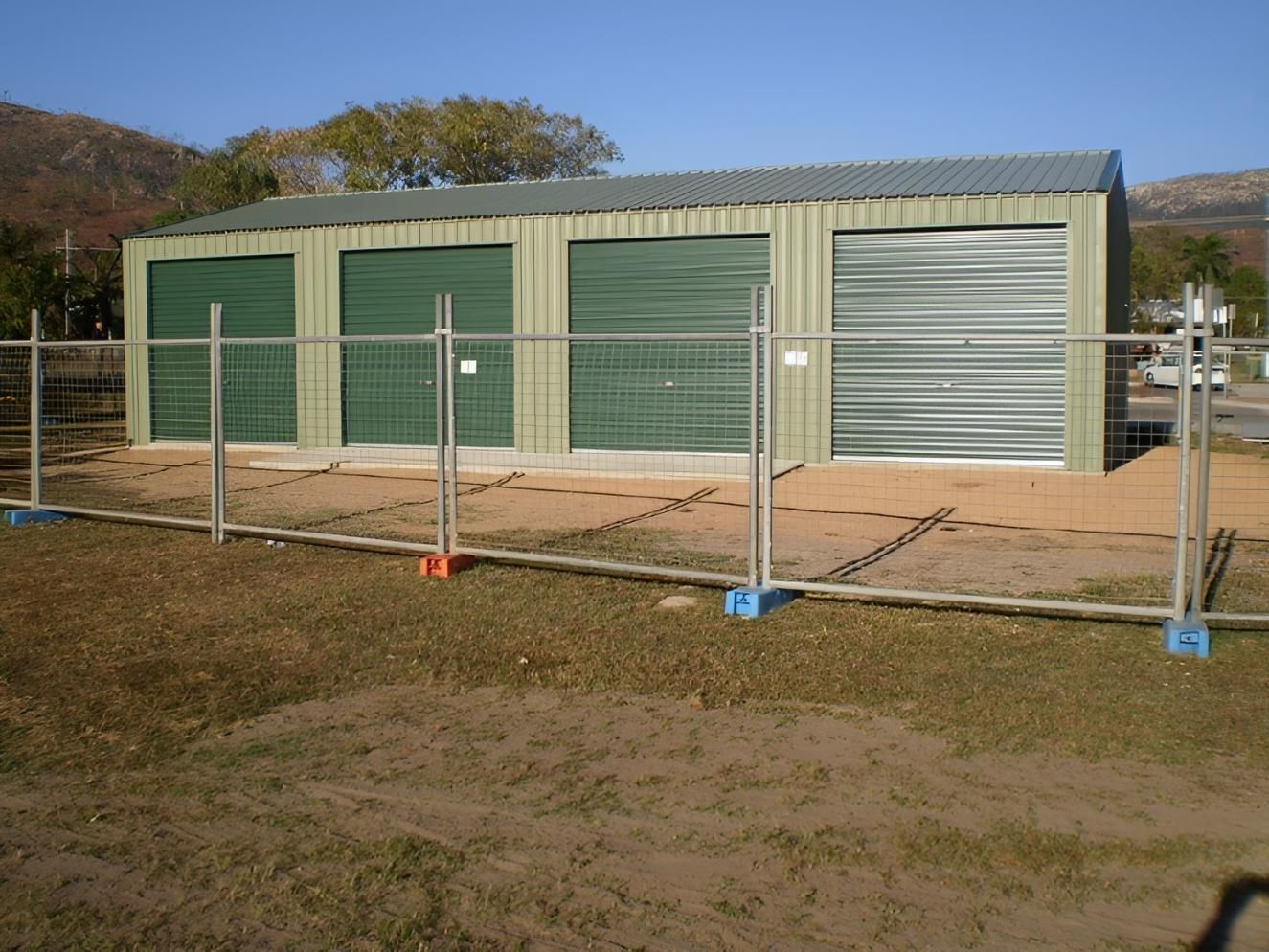 A Fence Surrounds A Building With Green Doors  — Shedquarters In Kirwan, QLD