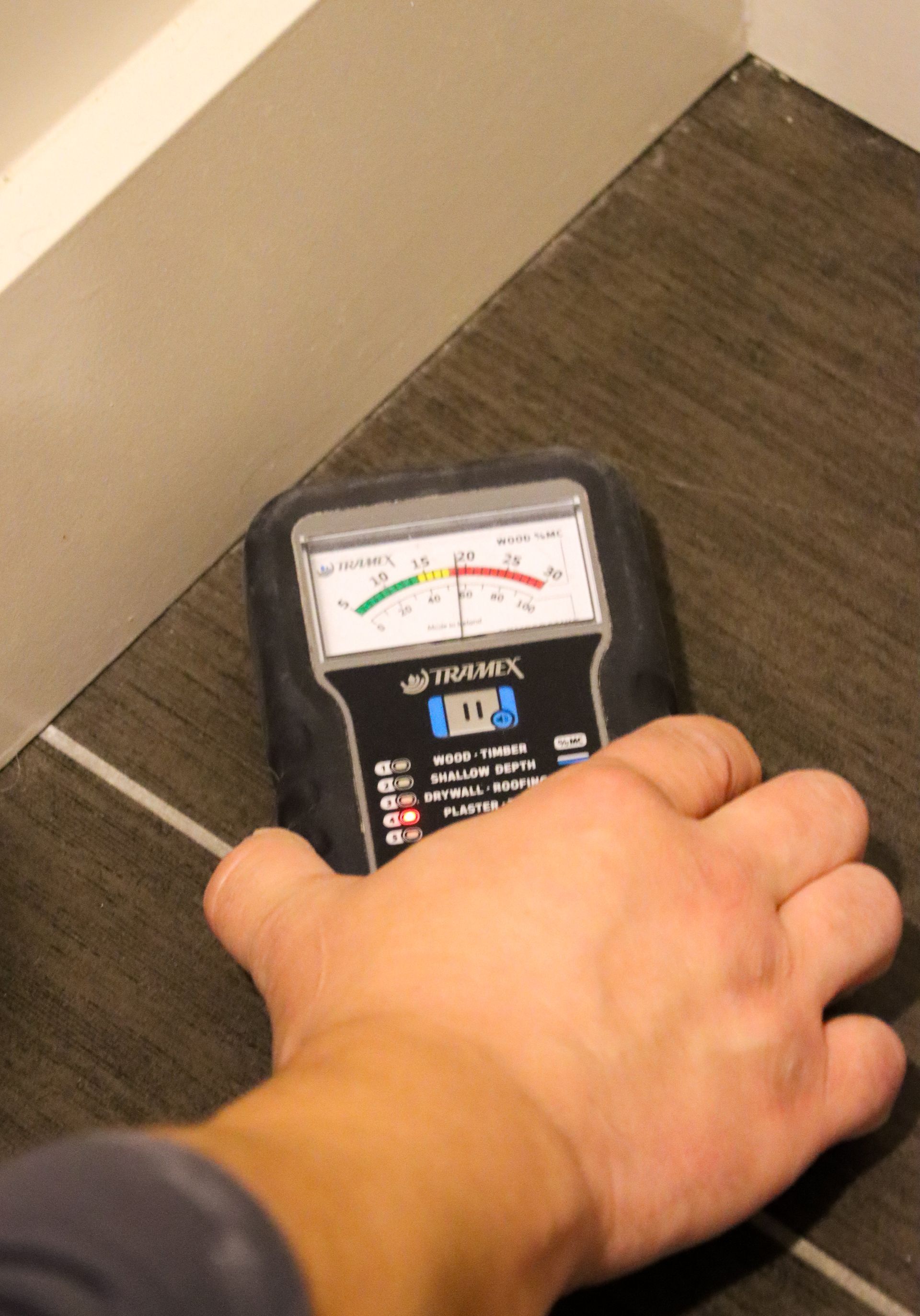 A person is holding a device that says ' thermometer ' on it