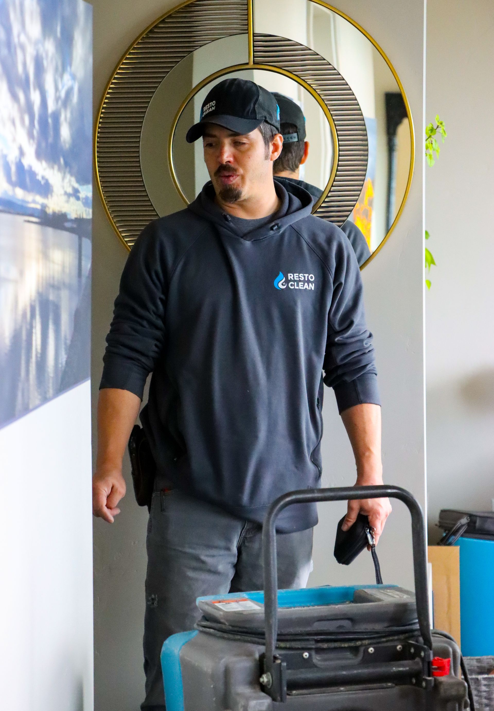 A man is standing in a room holding a vacuum cleaner.