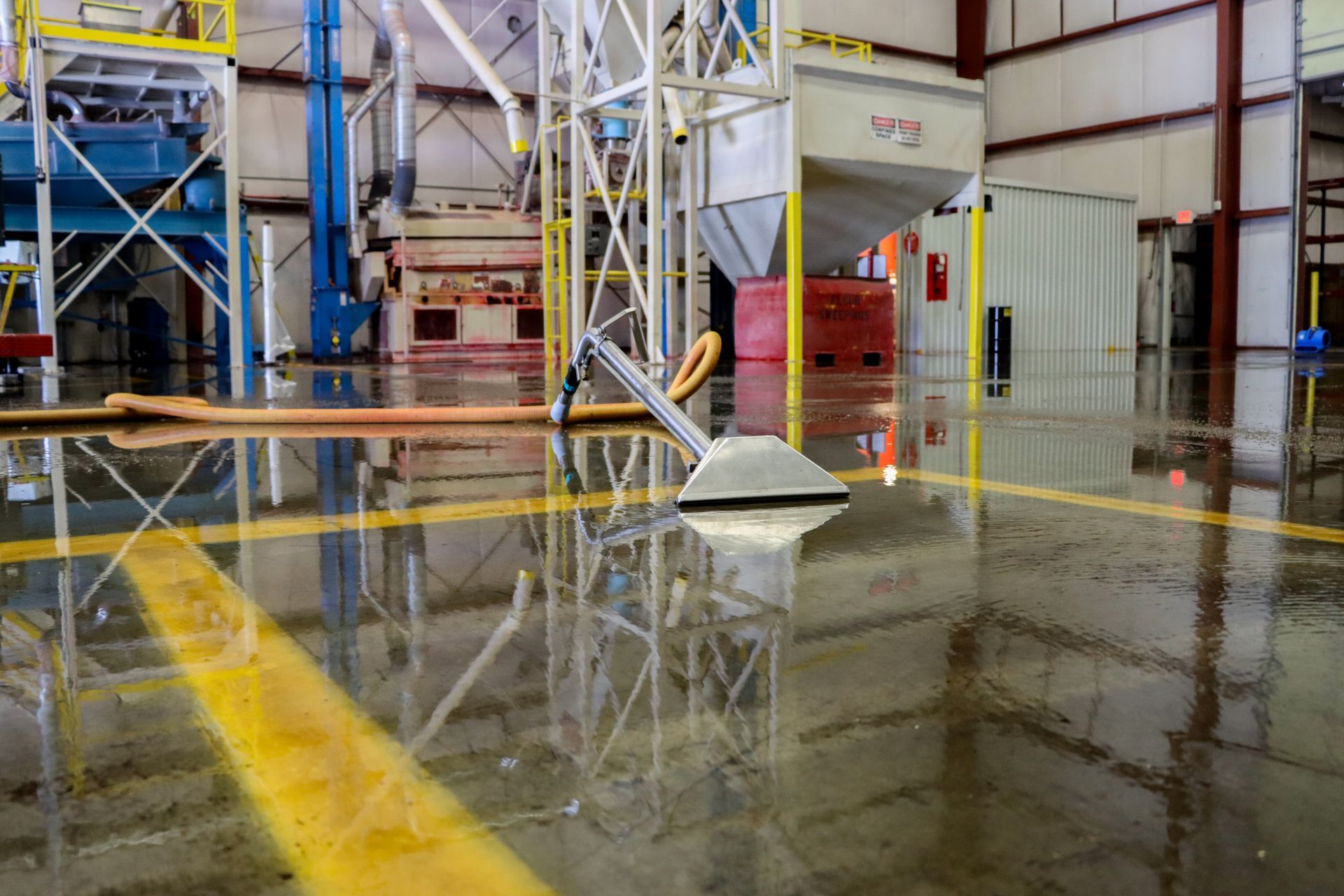 A vacuum cleaner is sitting on the floor of a warehouse.