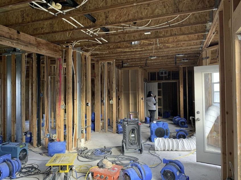A woman is standing in the middle of a building under construction.