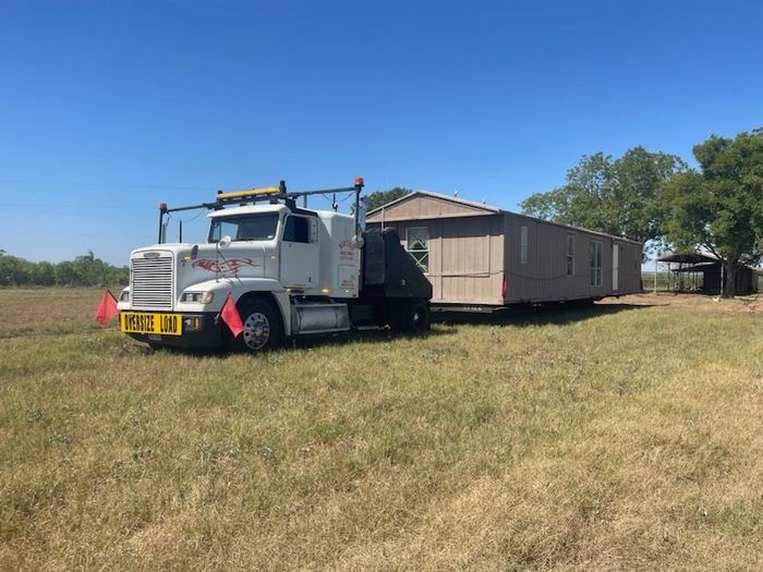 A truck is carrying an oversize load on the highway.