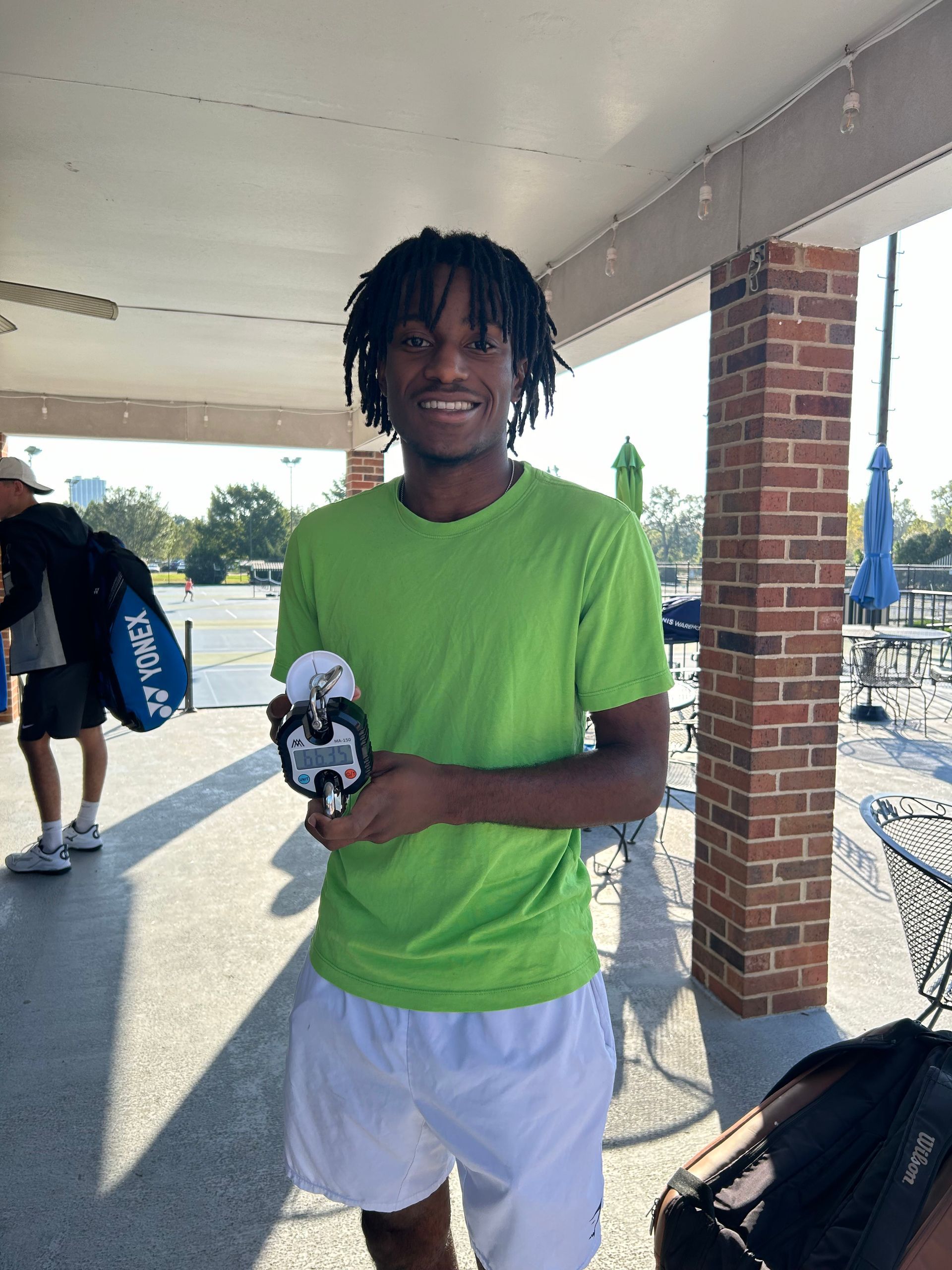 Tennis player testing his grip with a hand dynamometer after trying Gobi Grip