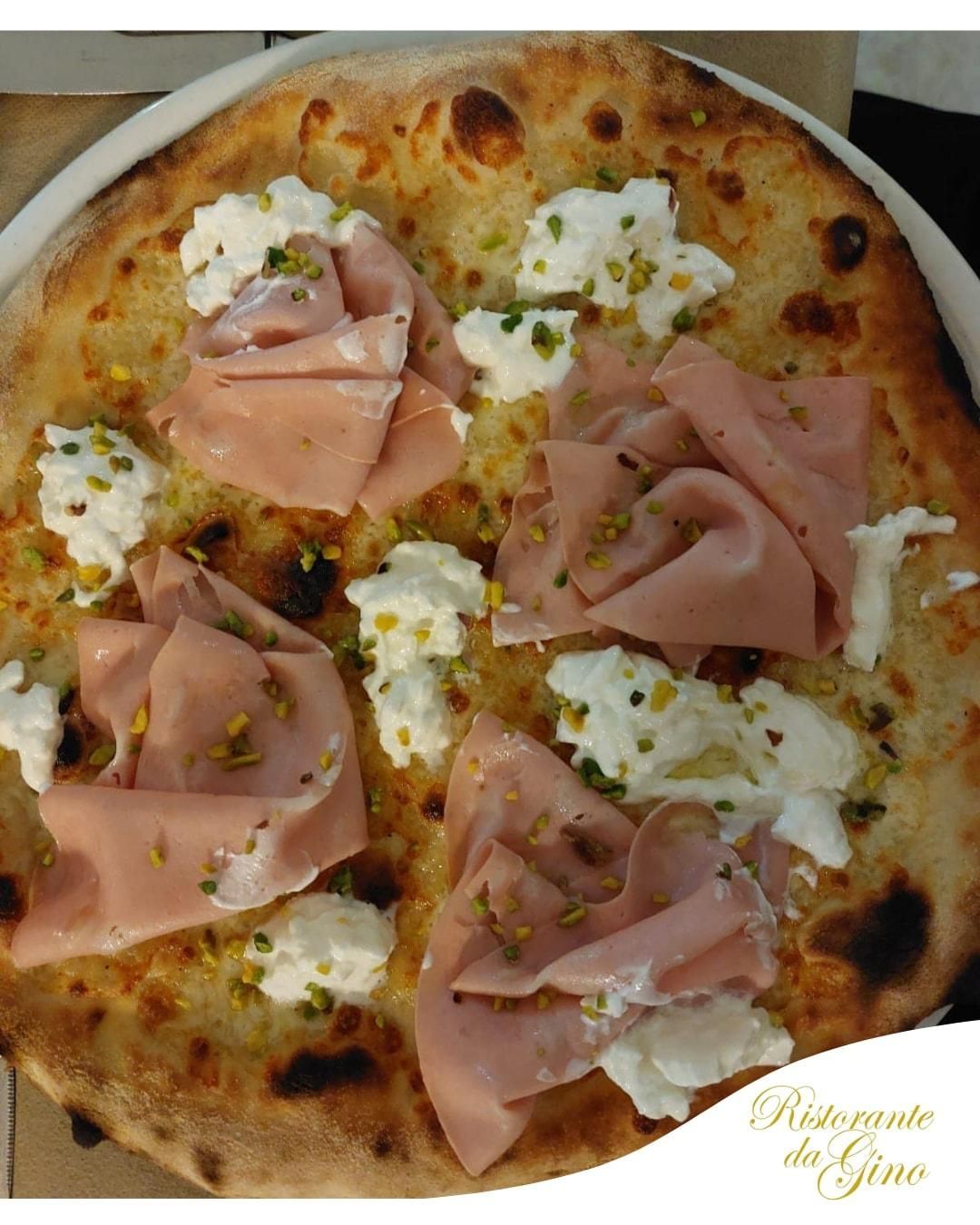 Pizza con prosciutto e fiocchi di ricotta su un piatto bianco