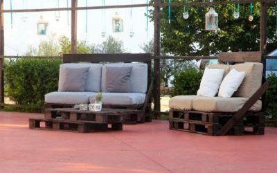 Due panchine imbottite da esterno su un patio con pavimento rosso e sfondo giardino.