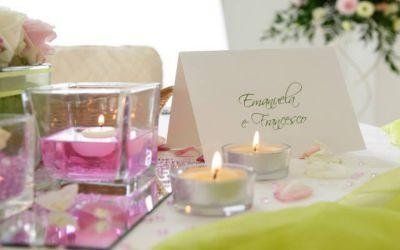 Elegante apparecchiatura della tavola con candele rosa, lumini e un biglietto con la scritta