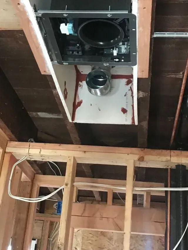 Exposed ceiling HVAC duct opening in unfinished room with wooden framing and joists exposed