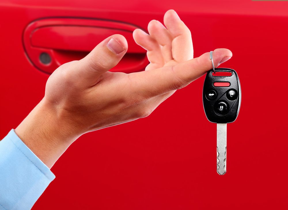 Hand Reaching for a Black Car Key Fob — Battery Assist Brisbane in Sandgate, QLD