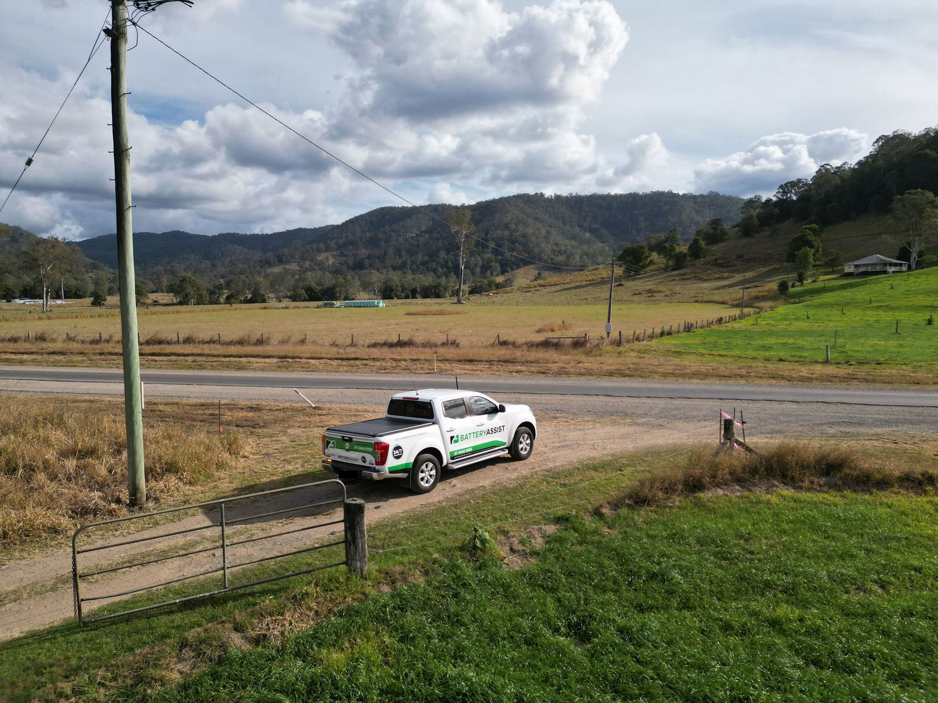 White Truck on Road in Rural Landscape With Mountains and Cloudy Sky — Battery Assist Brisbane in Deception Bay, QLD