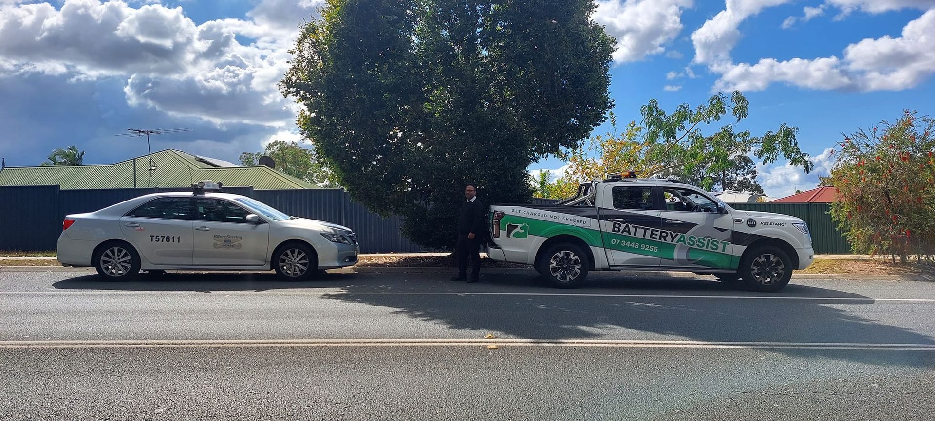A White Car and a Pickup Truck Are Parked on a Street — Battery Assist Brisbane in Narangba, QLD