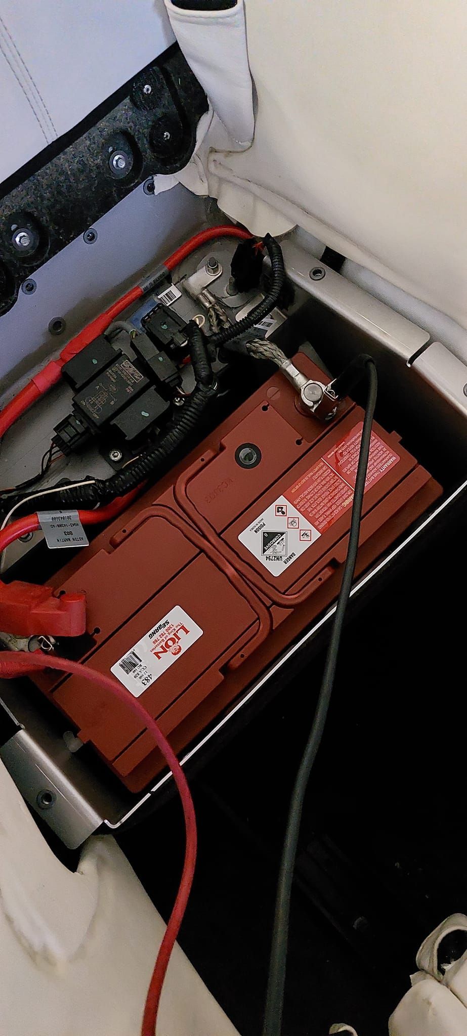 Red Battery in a Compartment With Red and Black Cables — Battery Assist Brisbane in Sandgate, QLD