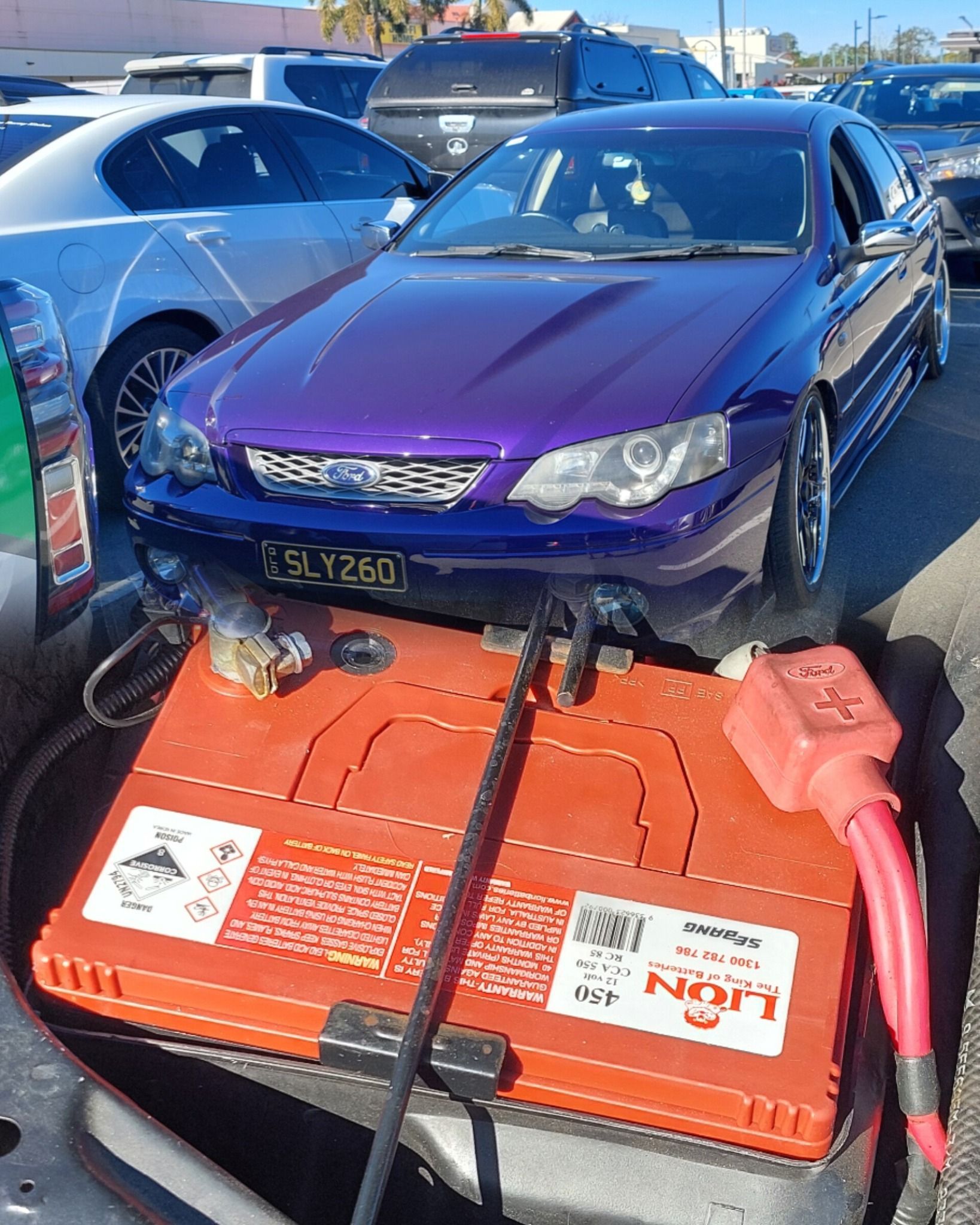 Purple Car Hooked to Orange Jump Starter in Parking Lot — Battery Assist Brisbane in Bracken Ridge, QLD