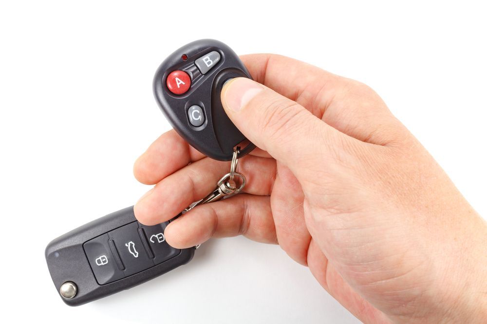 Hand Holding a Black Car Key Fob, Pressing a Button — Battery Assist Brisbane in Caloundra, QLD