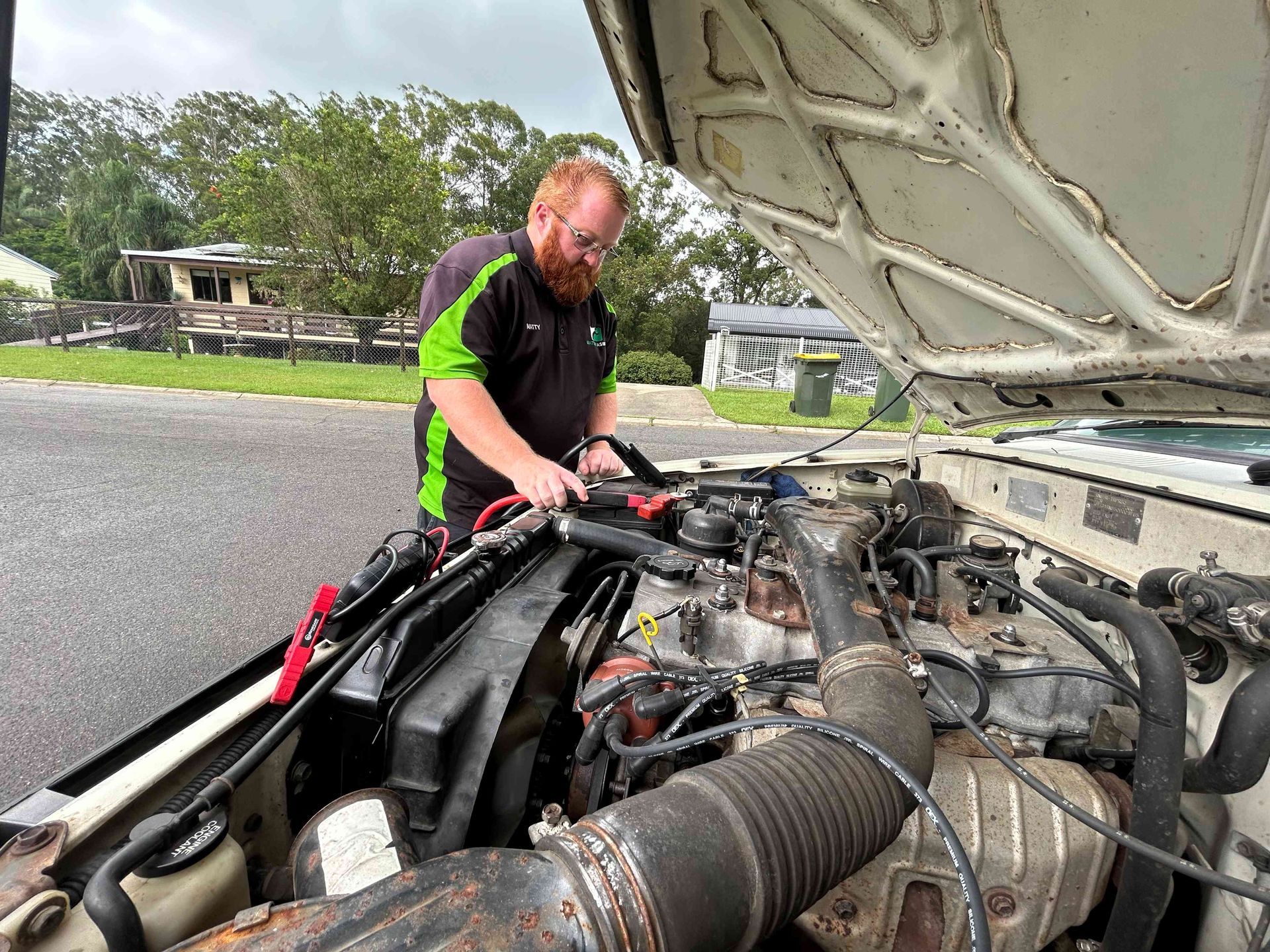 Mechanic Working on the Engine of a Car With the Hood Open — Battery Assist Brisbane in Caboolture, QLD