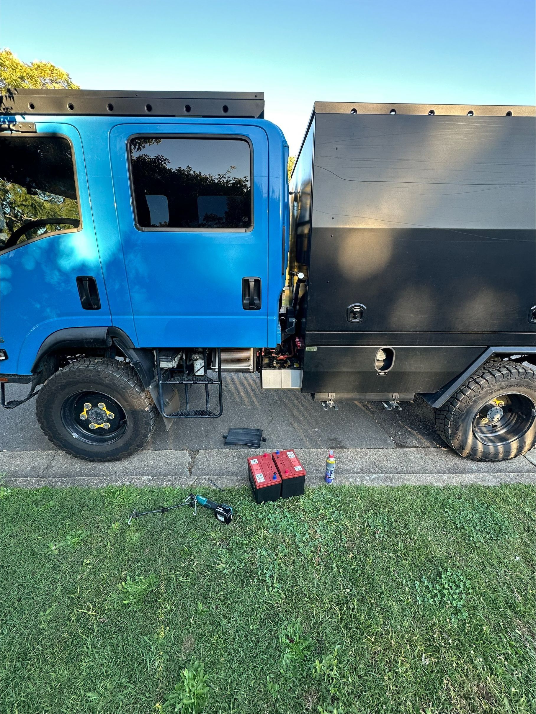Blue and Black Utility Truck Parked on Pavement Beside Grass — Battery Assist Brisbane in Chermside, QLD