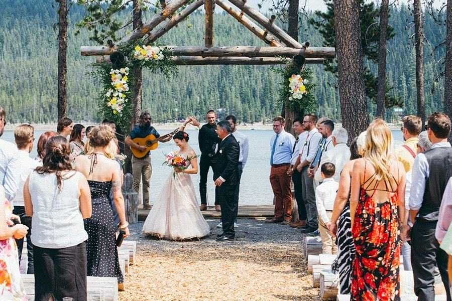 A bride and groom are getting married in front of a crowd of people.