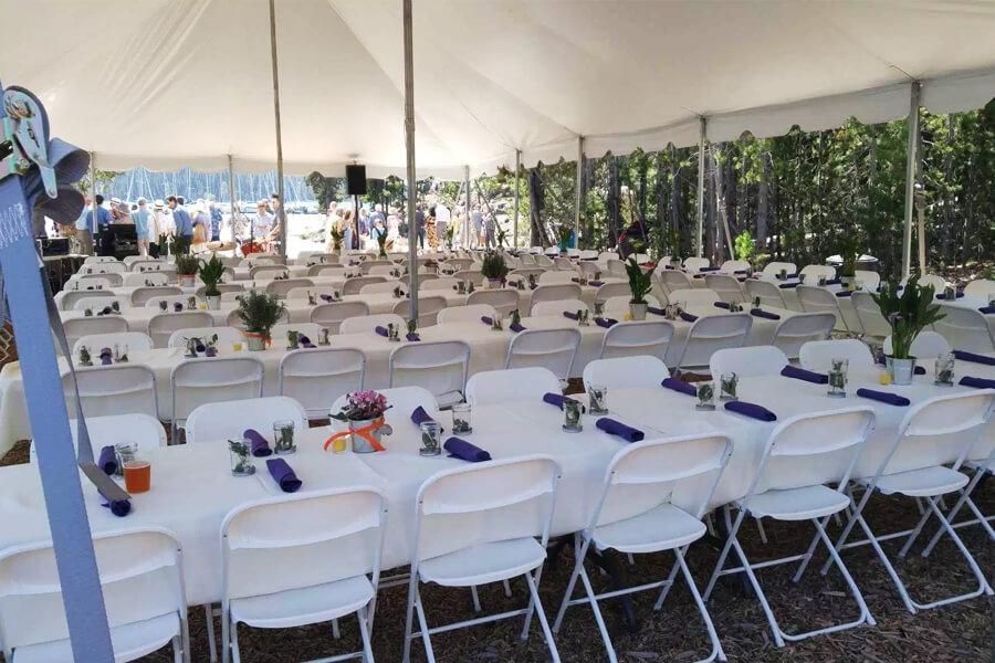 A large tent with tables and chairs set up for a party