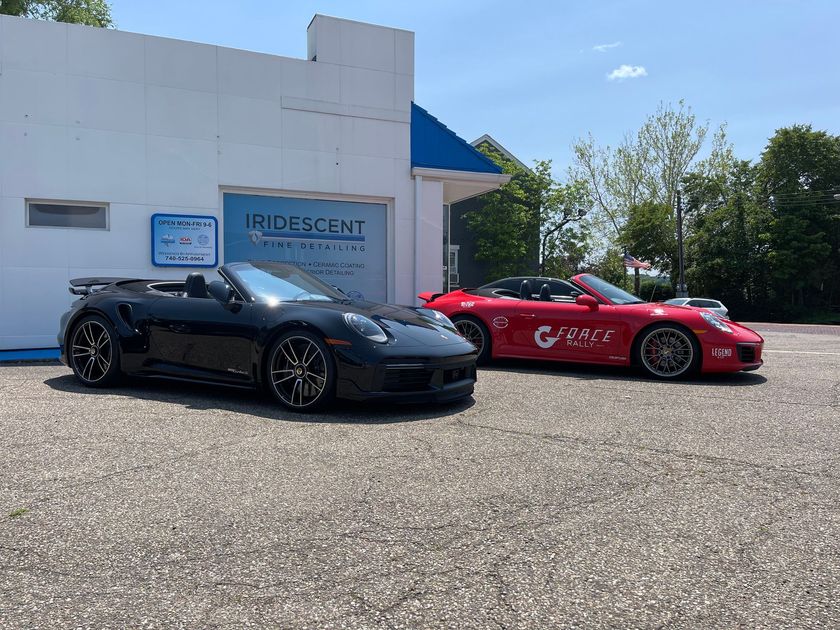 Two sports cars are parked in front of a building.