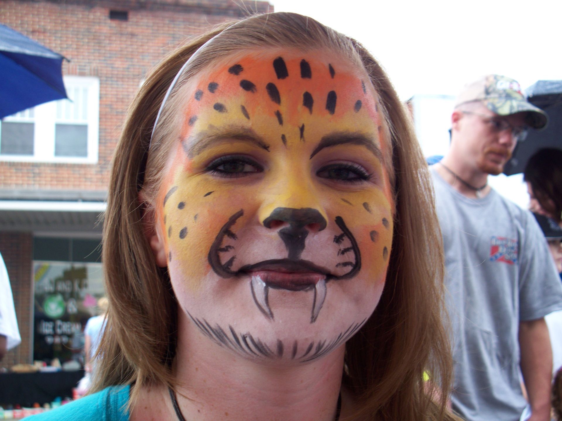 Woman with glitter and face art, wearing a leopard print mask.
