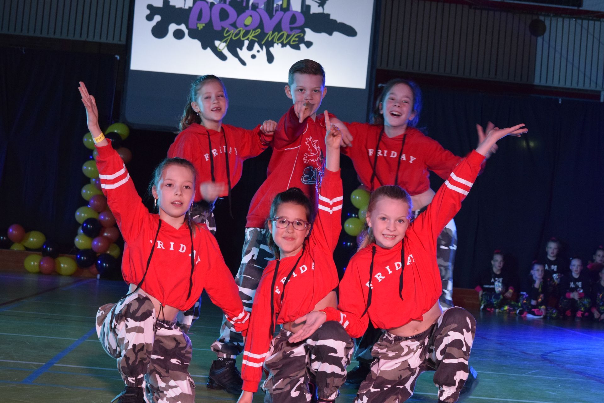 Een dansgroep treedt op het podium op. 