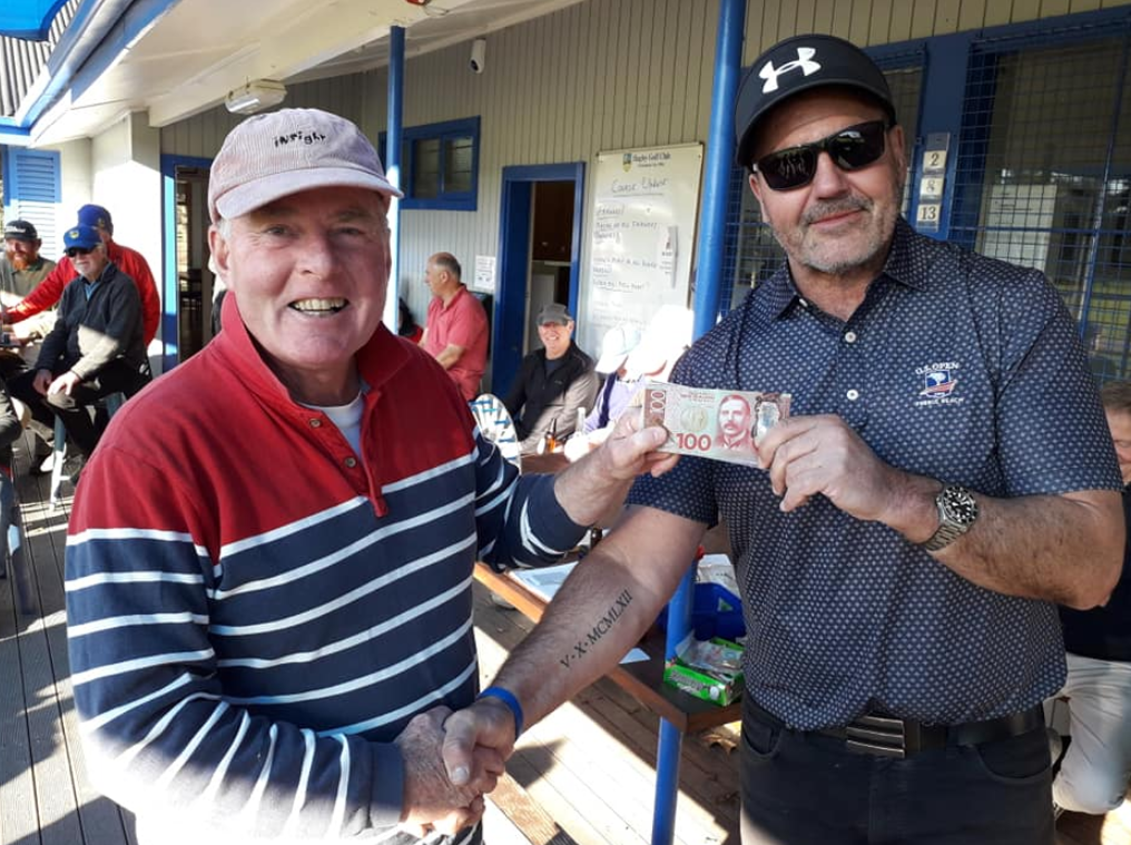Two men are standing next to each other holding a lottery ticket.