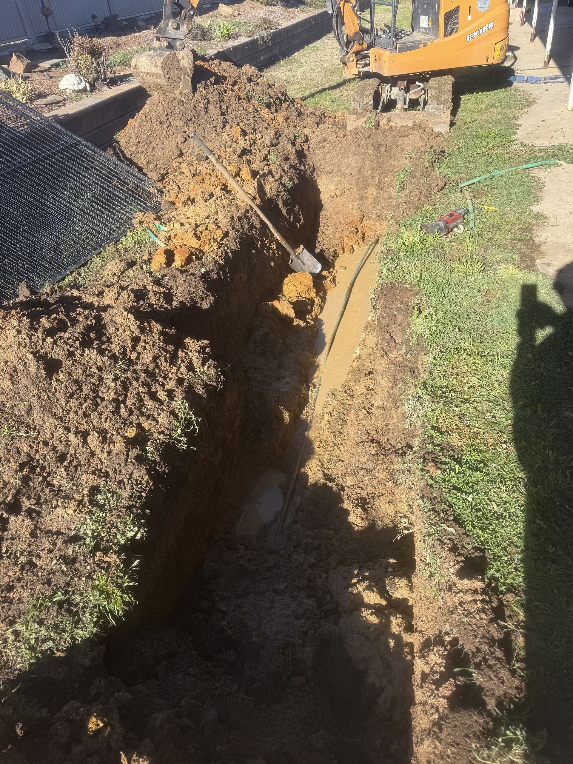 A yellow excavator is digging a hole in the ground.