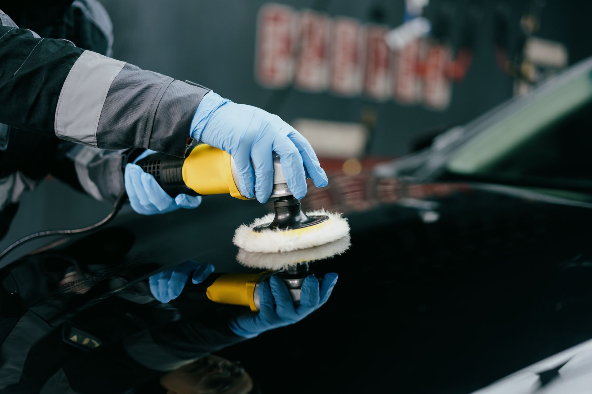 A person is polishing a car with a polisher.
