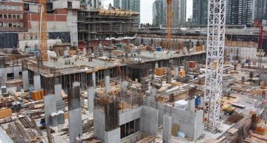 A large construction site with a lot of workers and cranes.