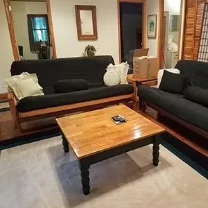Living room with two dark sofas and a wooden coffee table on a light rug