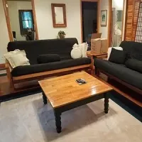 Living room with two dark sofas and a wooden coffee table on a light rug