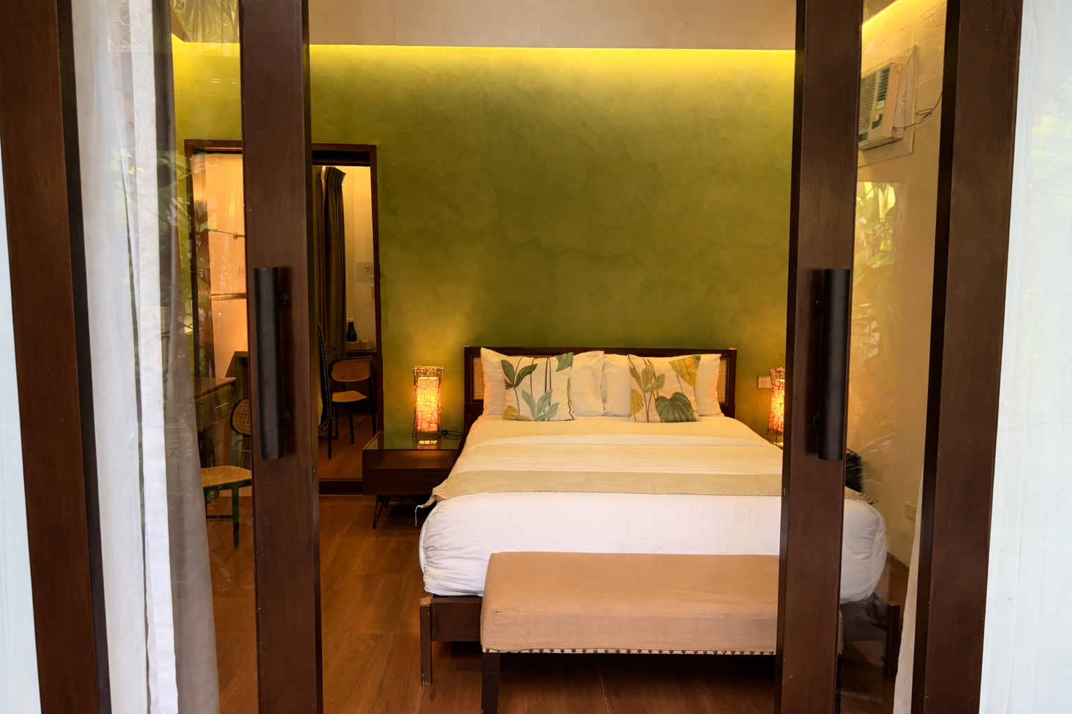 Cozy bedroom with a bed, wooden bench, and warm ambient lighting