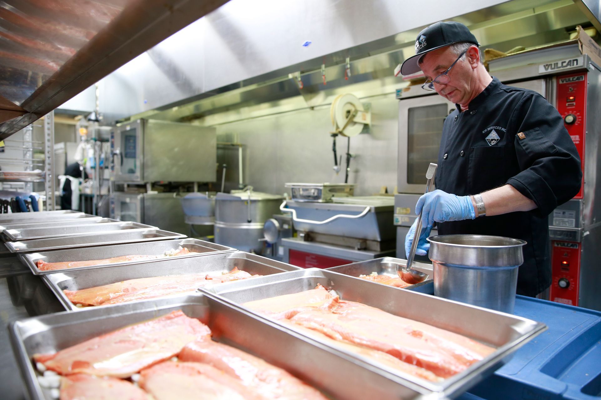 A chef is preparing food in a commercial kitchen.