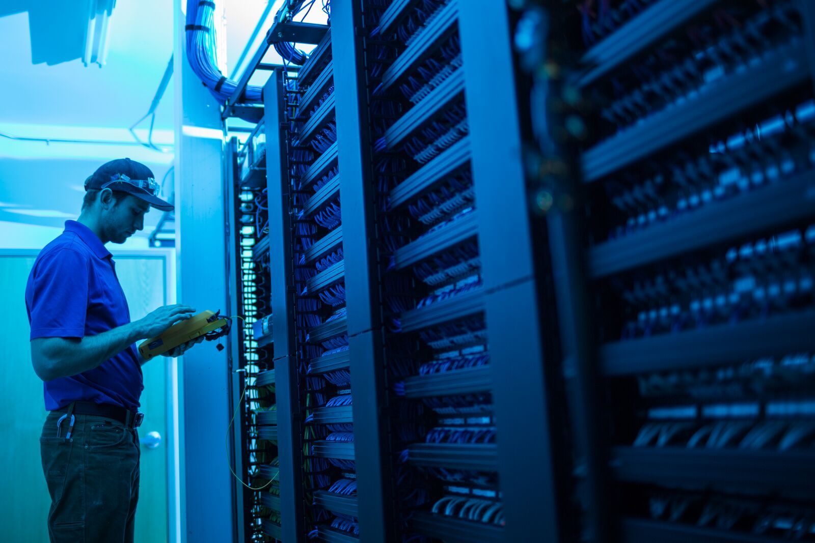A man is working on a server in a data center.
