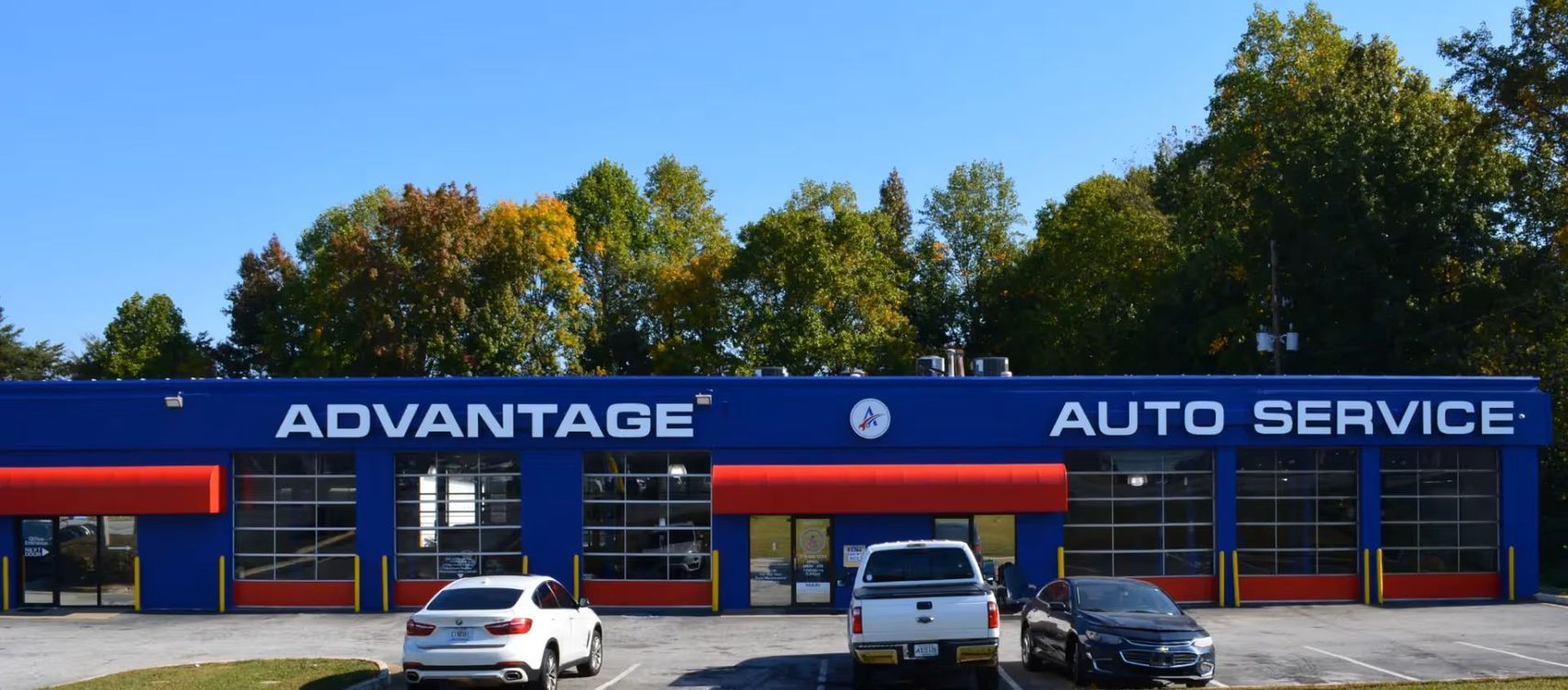 Advantage Auto Service storefront with blue exterior, red awnings, and cars parked in front