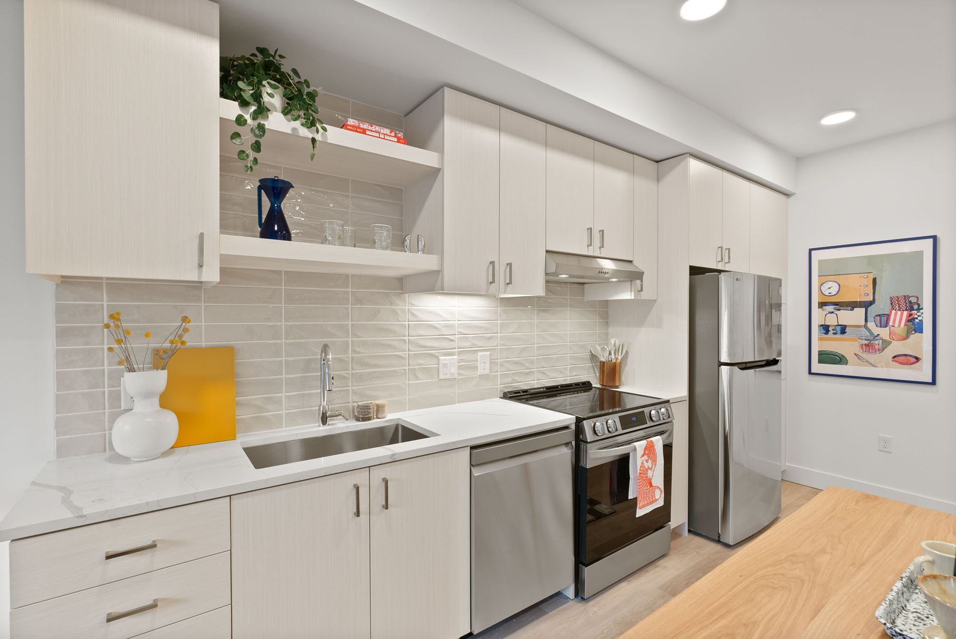 Modern kitchen with white cabinets, stainless steel appliances, and a wooden countertop.