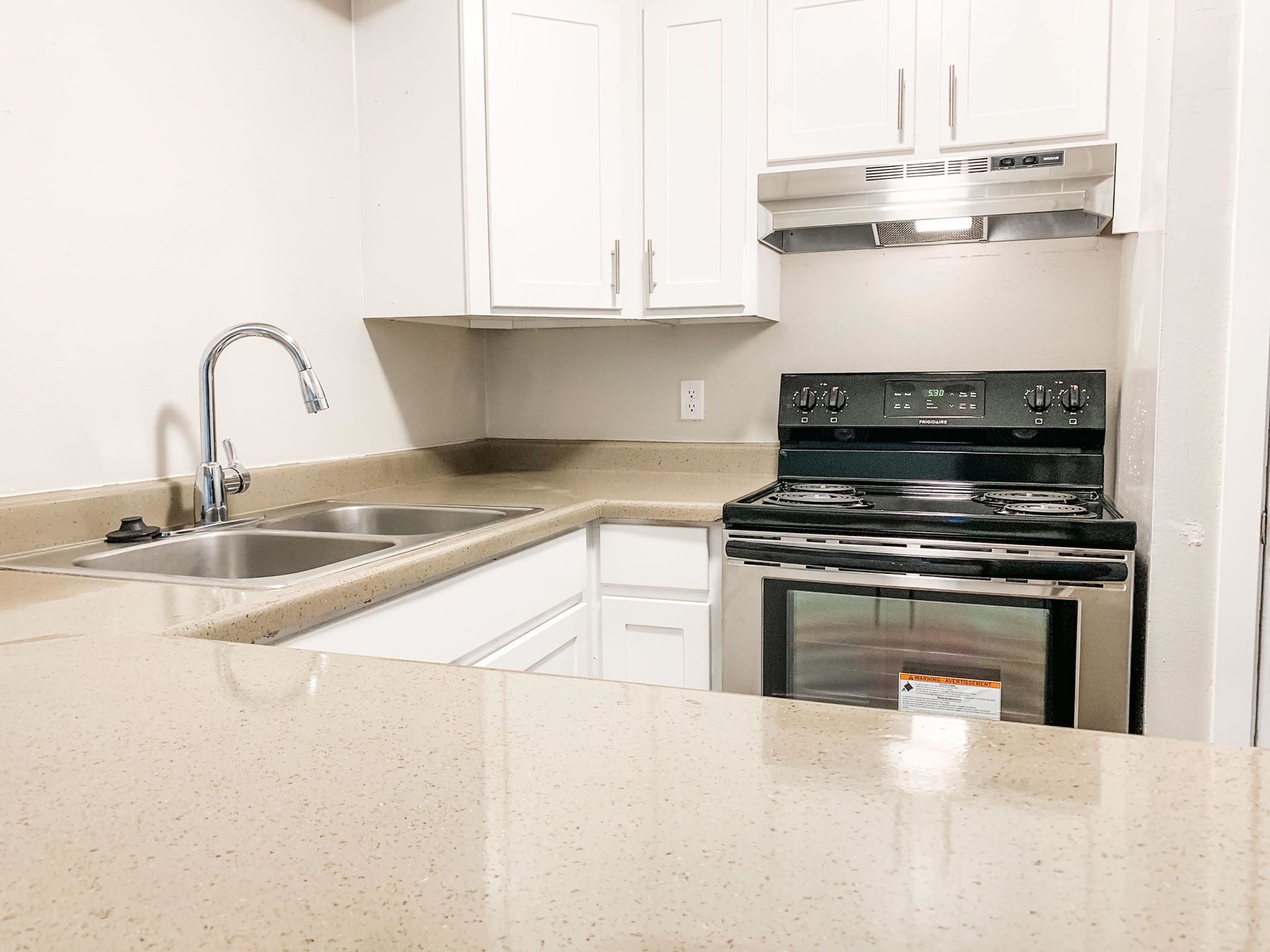 a kitchen with a stove , sink , and oven .