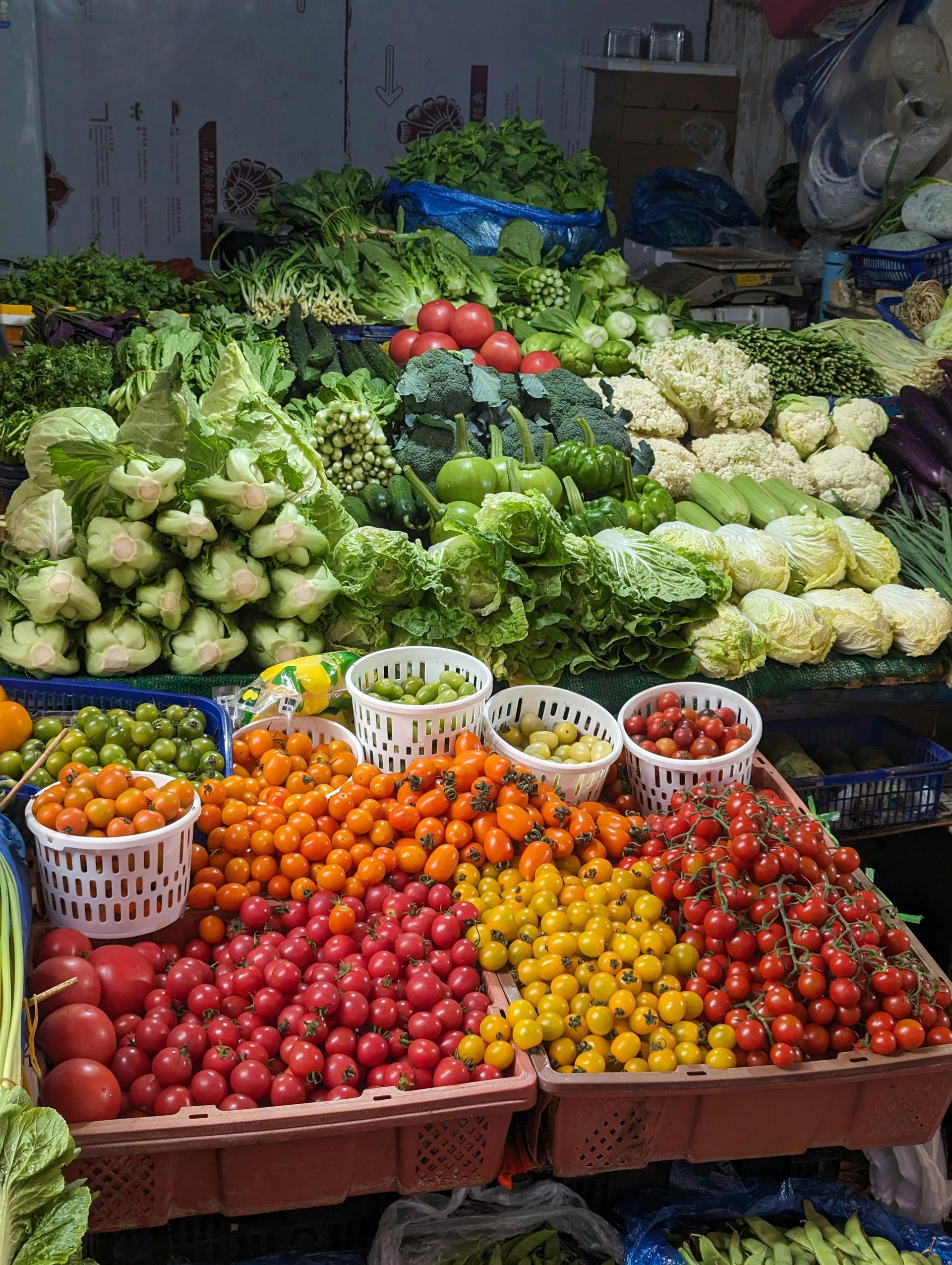 Een marktkraam met stapels kleurrijk fruit en groenten uitgestald.