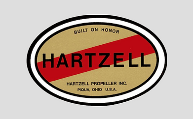 Hartzell propeller logo: Oval with gold background, red stripe, black border. 