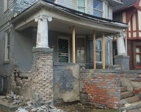 Close-up of crumbling brickwork & foundation damage on historic building before restoration by EFD Masonry in Metro Detroit.