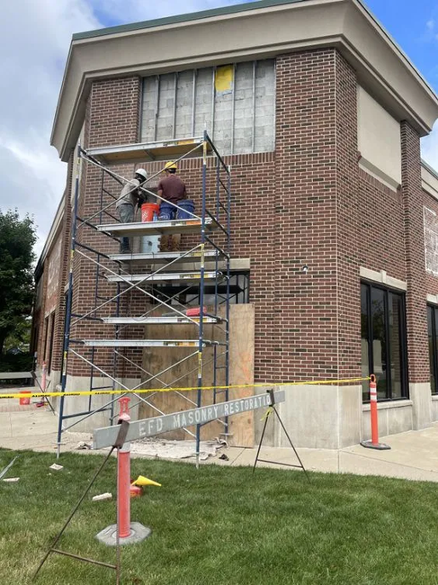 EFD Masonry Restoration team on scaffolding, repairing the brick façade at MSU Bank in Novi.