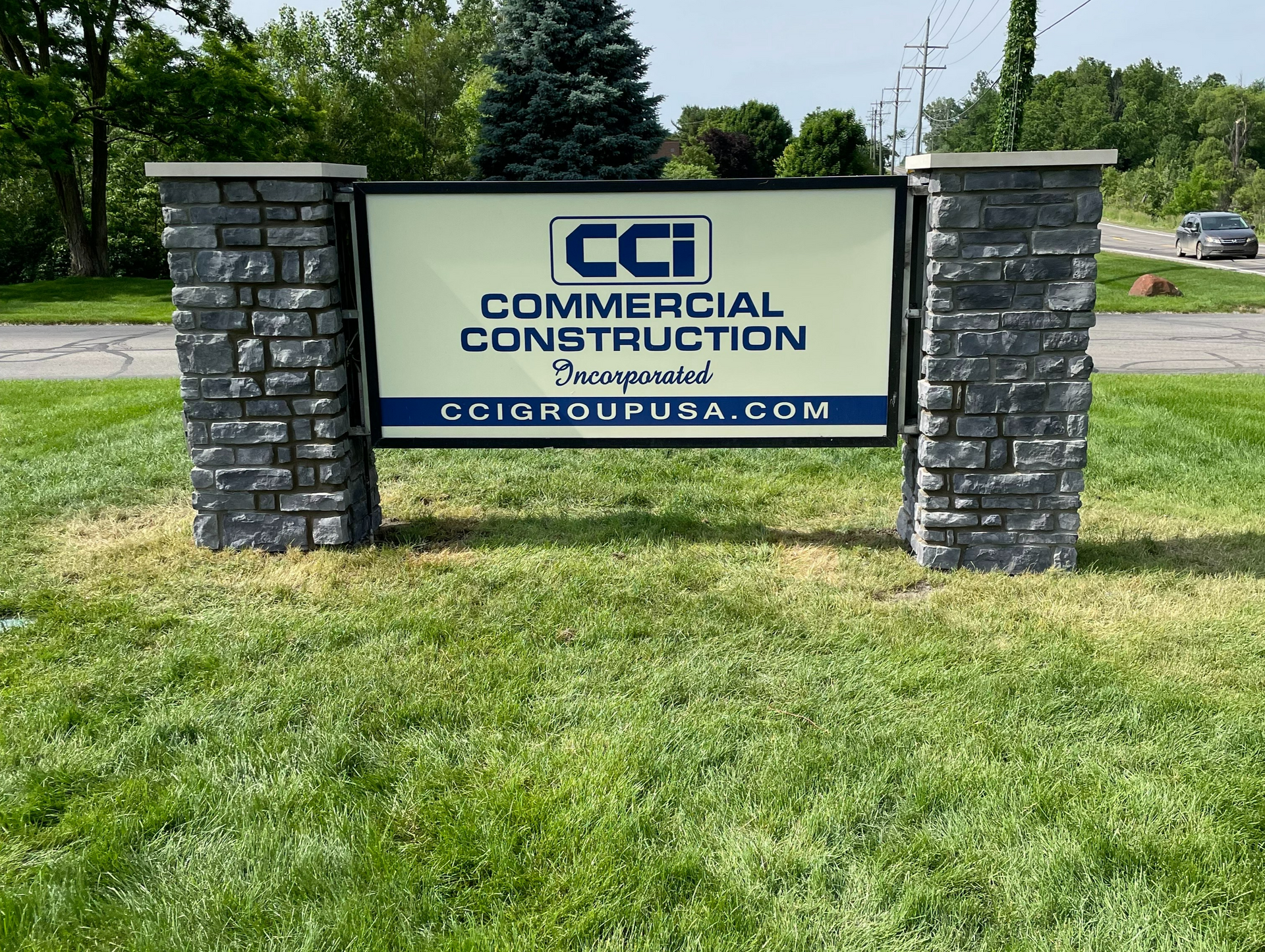 Stone pillars framing the CCI Commercial Construction sign, built by EFD Masonry in Livingston County.