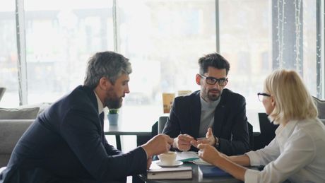 A business meeting between two men and a woman